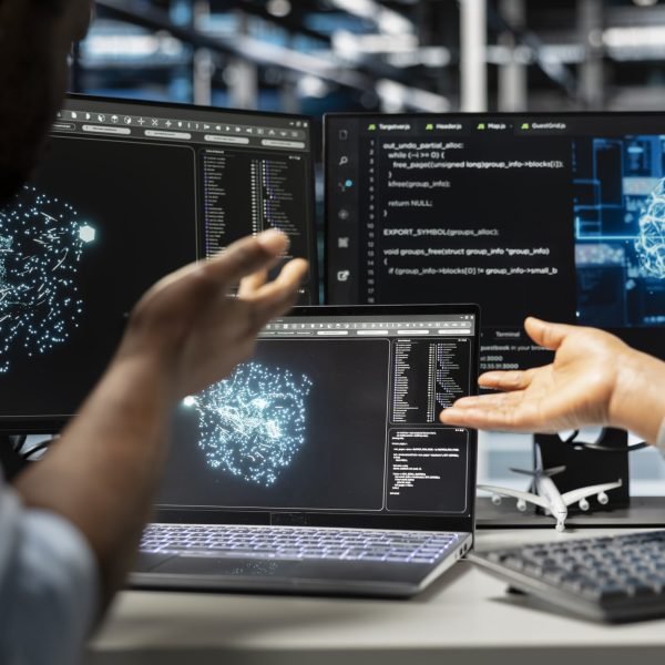 Server farm engineering team looks at data analysis graph to reduce supercomputers failure. Data center coworkers look at AI visualization dashboard to pinpoint gear performance glitches